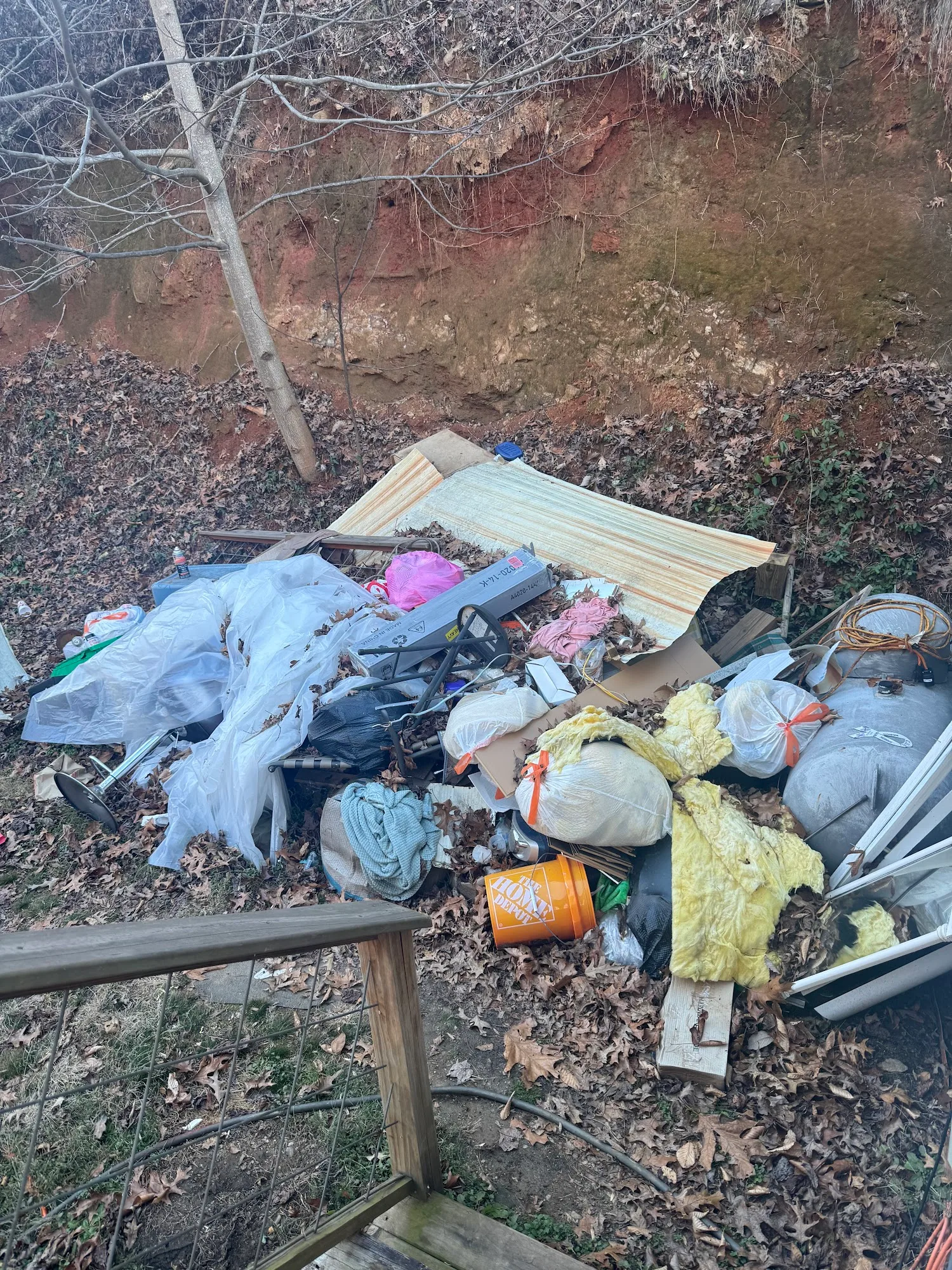 Hillside before — trash and debris piled on slope